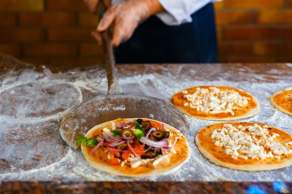 El chef va a poner la pizza en el horno . — Foto de Stock