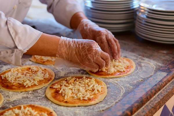 Шеф-кухар, який кладе начинки на піцу — стокове фото