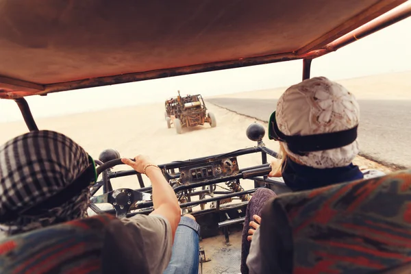 Fiatal pár lovaglás buggy autót sivatagban — Stock Fotó