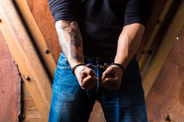 Tattooed hands of a criminal handcuffed — Stock Photo, Image