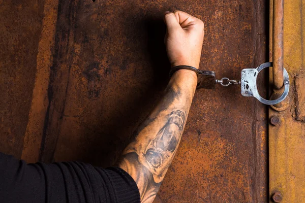 Tattooed hand of a criminal handcuffed — 스톡 사진