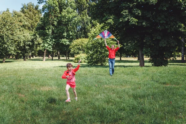 The girl and her father play with a kite. — Stock Photo, Image