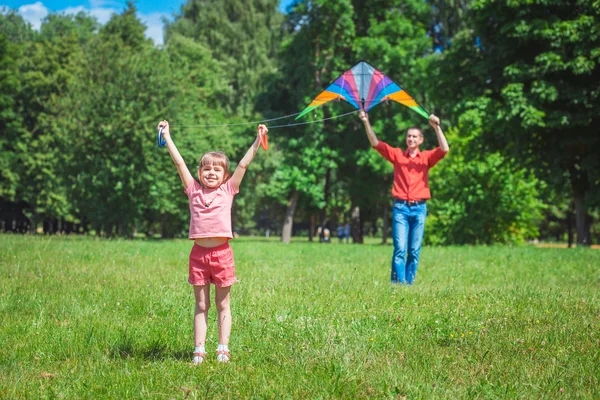 A menina e seu pai brincam com um papagaio . — Fotografia de Stock