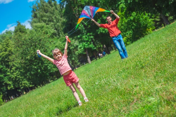 La niña y su padre juegan con una cometa . —  Fotos de Stock