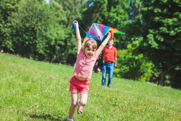 Das Mädchen und ihr Vater spielen mit einem Drachen. — Stockfoto