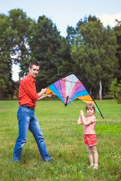 Het meisje en haar vader spelen met een vlieger. — Stockfoto