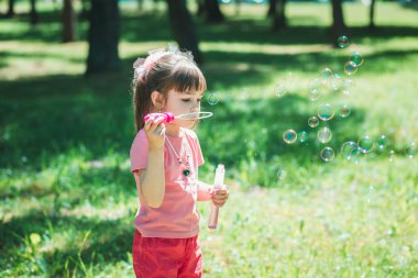Küçük kız sabun köpüğüyle oynuyor. 