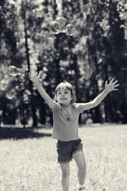 Küçük kız sabun köpüğüyle oynuyor. 