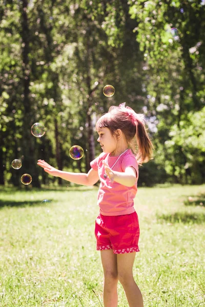 Little girl playing with soap bubbles — Stock Photo, Image