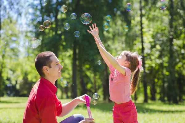 Батько і його дочка роблять бульбашки — стокове фото