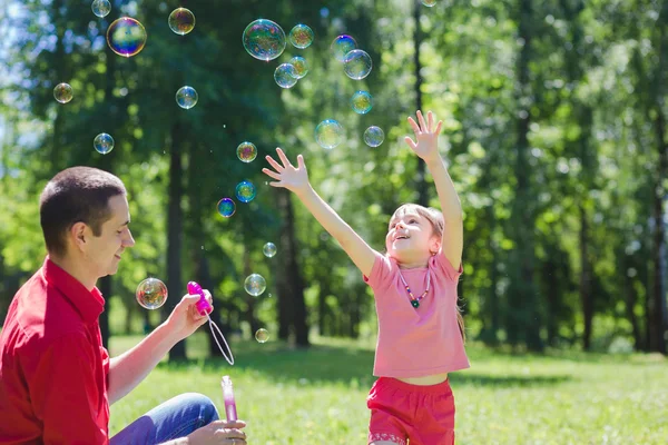 Dad and his daughter are making bubbles — Stock Photo, Image