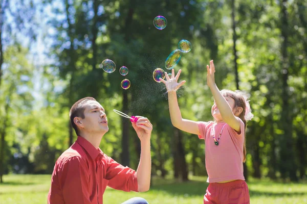 Батько і його дочка роблять бульбашки — стокове фото