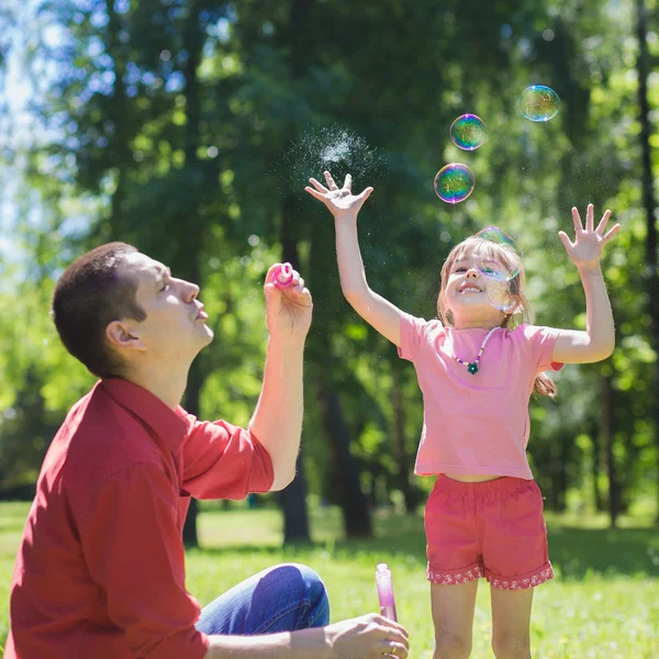 Dad and his daughter are making bubbles — Stock Photo, Image