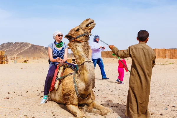 Arab boy rolls tourists on a camel. — Stock Photo, Image