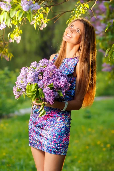 Mode ung kvinna med lila blommor — Stockfoto