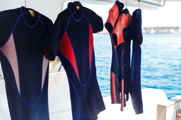 Hanging wetsuits — Stock Photo, Image