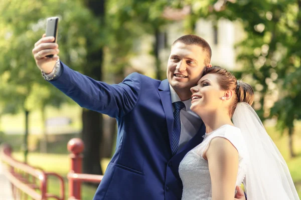 Bruid en bruidegom maken selfie — Stockfoto