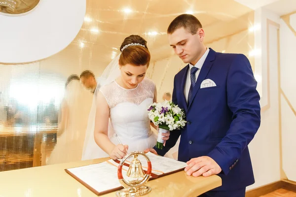 Bride and groom signing marriage license — ストック写真