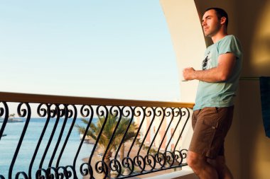 Balkonda duran yakışıklı adam