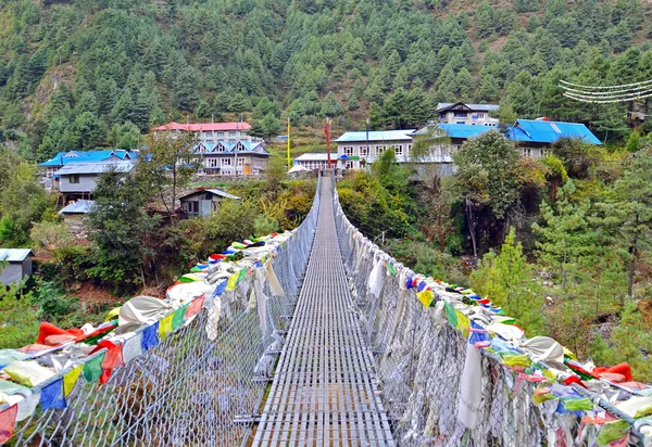 Suspension bridge with prayer flags  in village of Jorsale — Stock Photo, Image
