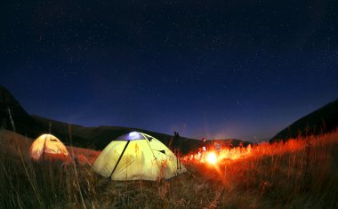 Işıklı sarı kamp çadırı, gece yıldızların altında