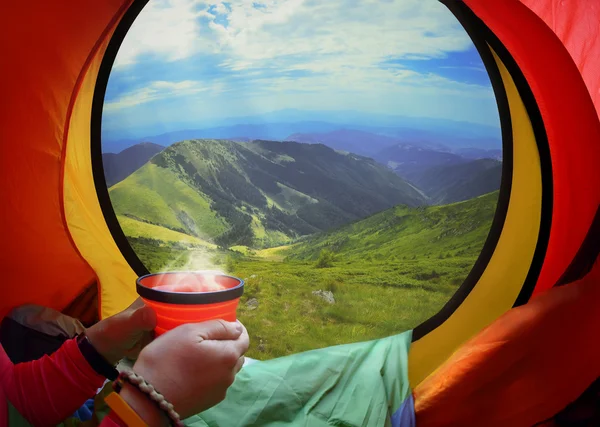 Frau liegt im Zelt mit Kaffee, Blick auf Berge und Himmel — Stockfoto