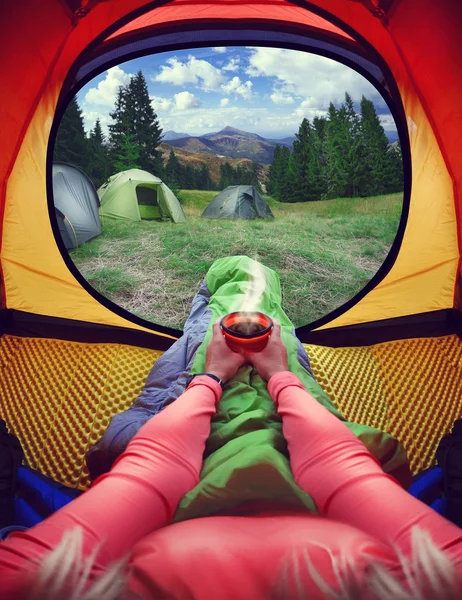 女人躺在帐篷里与咖啡、 山脉和天空的视图 — 图库照片