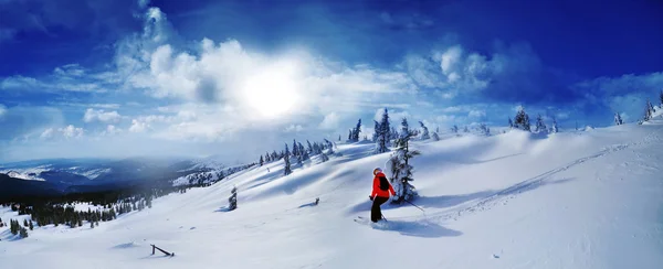 Skier skiing downhill in high mountains against sunset — Stock Photo, Image