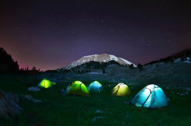 Işıklı sarı kamp çadırı, gece yıldızların altında