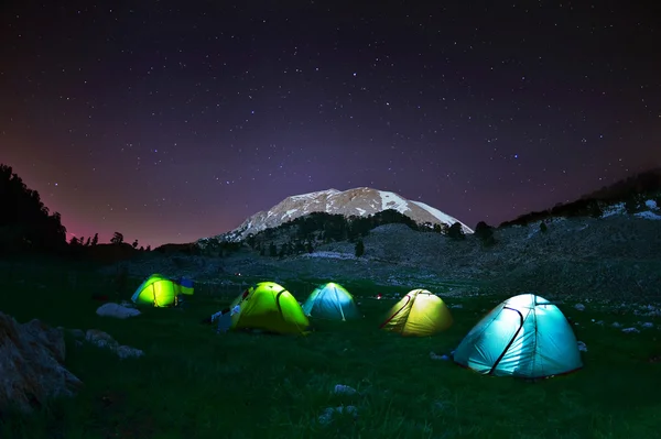 Belyst gul camping tält under stjärnorna på natten — Stockfoto