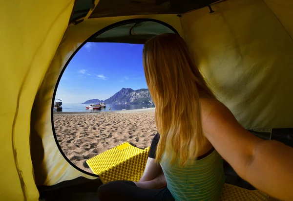 Gelukkige vrouw zitten in een tent, uitzicht op bergen, hemel en zee — Stockfoto