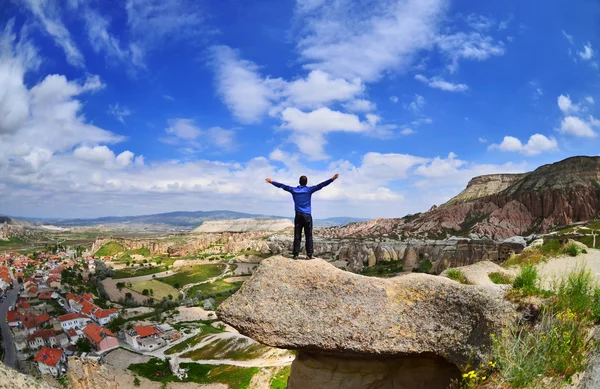 Jeune garçon sur une pierre avec les mains levées à Goreme, en Cappadoce , — Photo