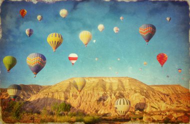 Grunge image  of colorful hot air balloons against blue sky