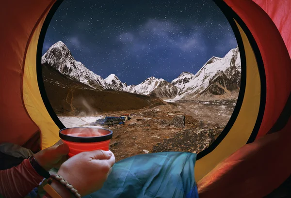 Femme couchée dans une tente avec café, vue sur les montagnes et la nuit s — Photo