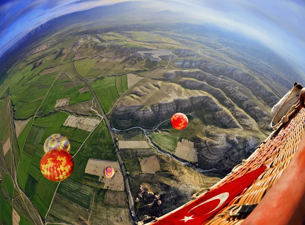 Colorido globo aerostático volando sobre el paisaje rocoso en el cielo azul —  Fotos de Stock