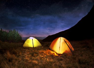 Işıklı sarı kamp çadırı, gece yıldızların altında
