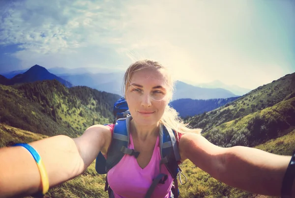 Una joven sonriente se toma una selfie en el pico de la montaña en Carpathi —  Fotos de Stock