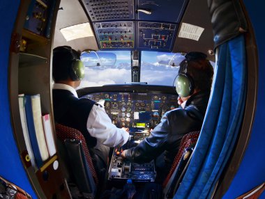 Eski yolcu uçağı pilotları, dağlar ve pencerenin dışındaki gökyüzü ile kabin
