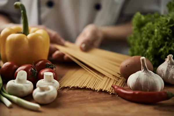 Chef sosteniendo pasta cruda — Foto de Stock