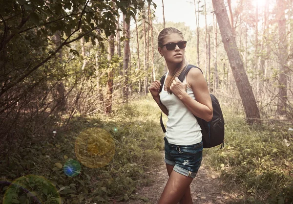 Žena batohem v lese — Stock fotografie