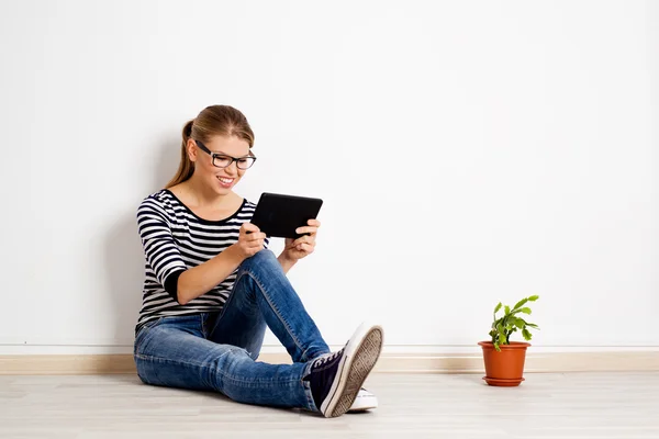 Woman at empty wall with tablet pc — Stock Photo, Image