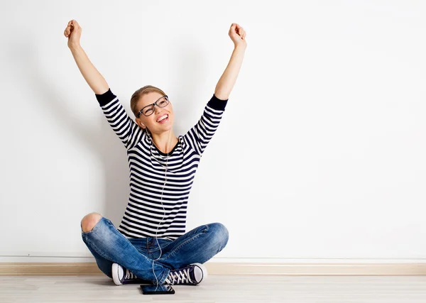 Woman at wall listening music — Stock Photo, Image