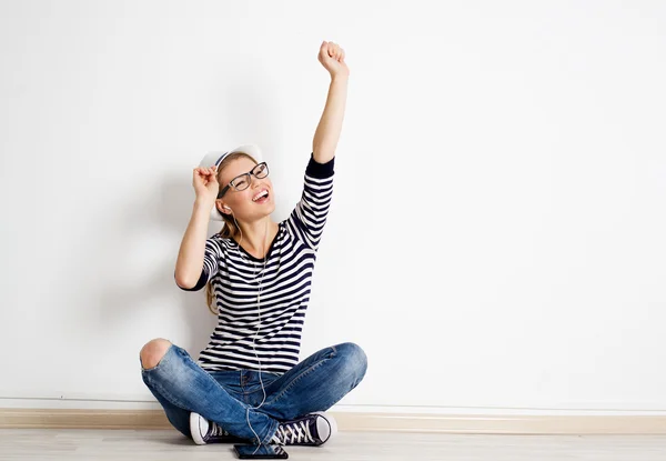 Woman at wall listening music — Stock Photo, Image