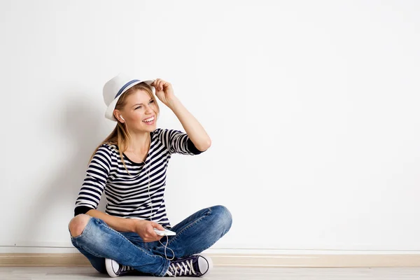 Woman at wall listening music — Stock Photo, Image