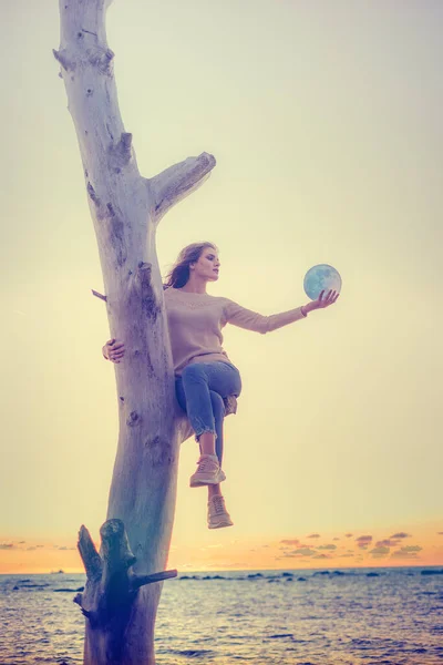 Dziewczyna trzyma księżyc w rękach. Zachód słońca nad morzem. Marzenia się spełniają.. — Zdjęcie stockowe