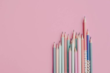 Renkli kalemler ve pembe arkaplan üstü görünümü