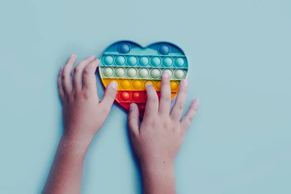 Top view pop it fidget juguete anti estrés en manos de niños — Foto de Stock