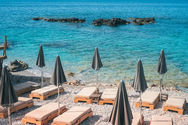 Arnavutluk 'ta Dhermi sahilinin turkuaz suyu ve şemsiyesi sakin görünüyor 