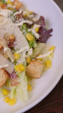 Yakın çekim şefi kamera önünde lezzetli sezar salatası sunar. Ağır çekim. Yüksek kaliteli FullHD görüntüler