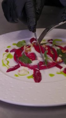 Renkli bir ravioli zarif bir şekilde kaplanıp süslenir. Zengin soslu makarnanın canlı renkleri. Yüksek kaliteli FullHD görüntüler